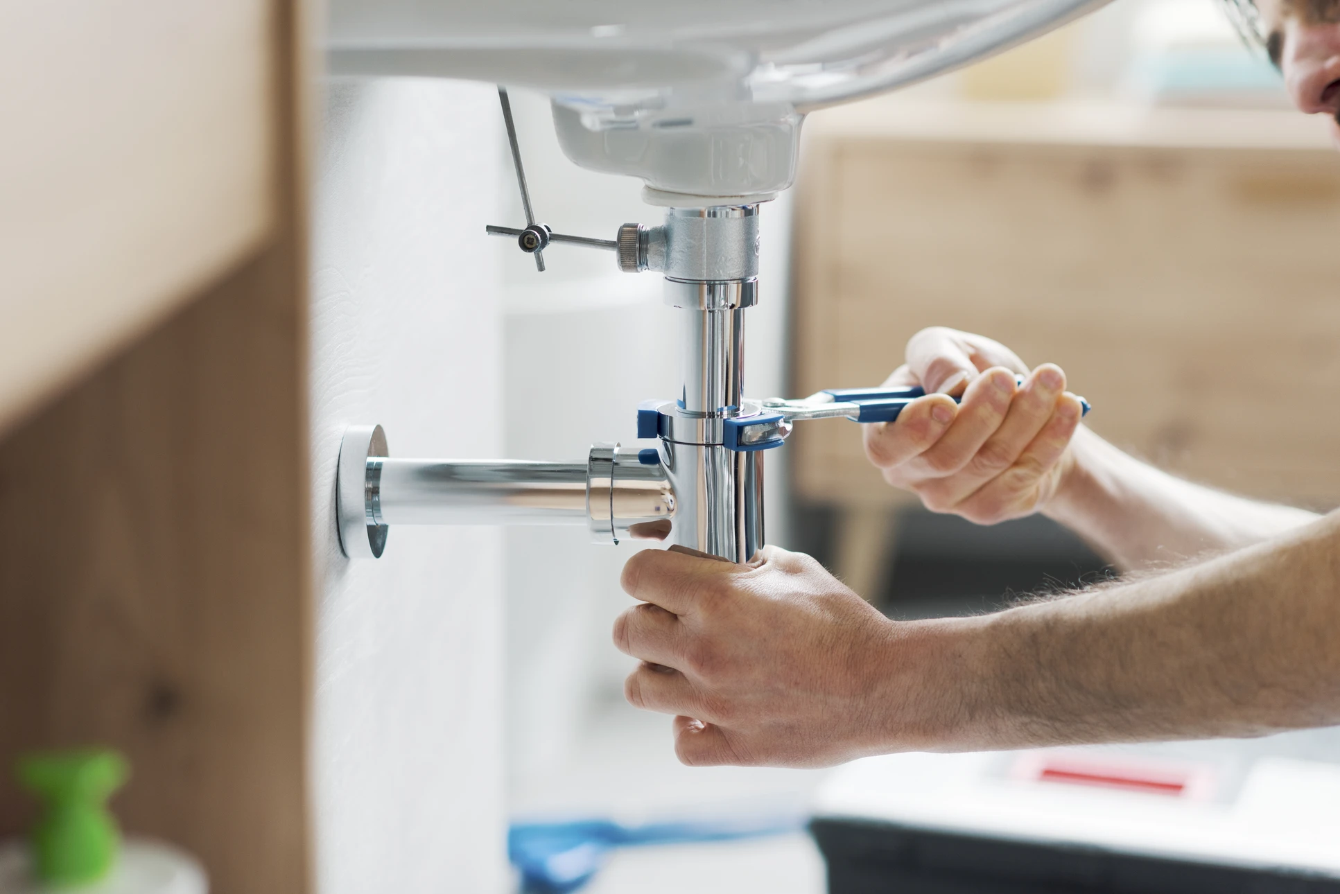 Intérieur résidentiel, plombier en action sous évier de cuisine